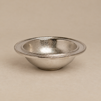 A small metallic silver bowl with a textured, hammered finish, shown on a neutral beige background.