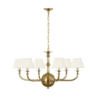 Acres Market & Interiors Embers 41" brass chandelier with five cream pleated shades and a central globe.