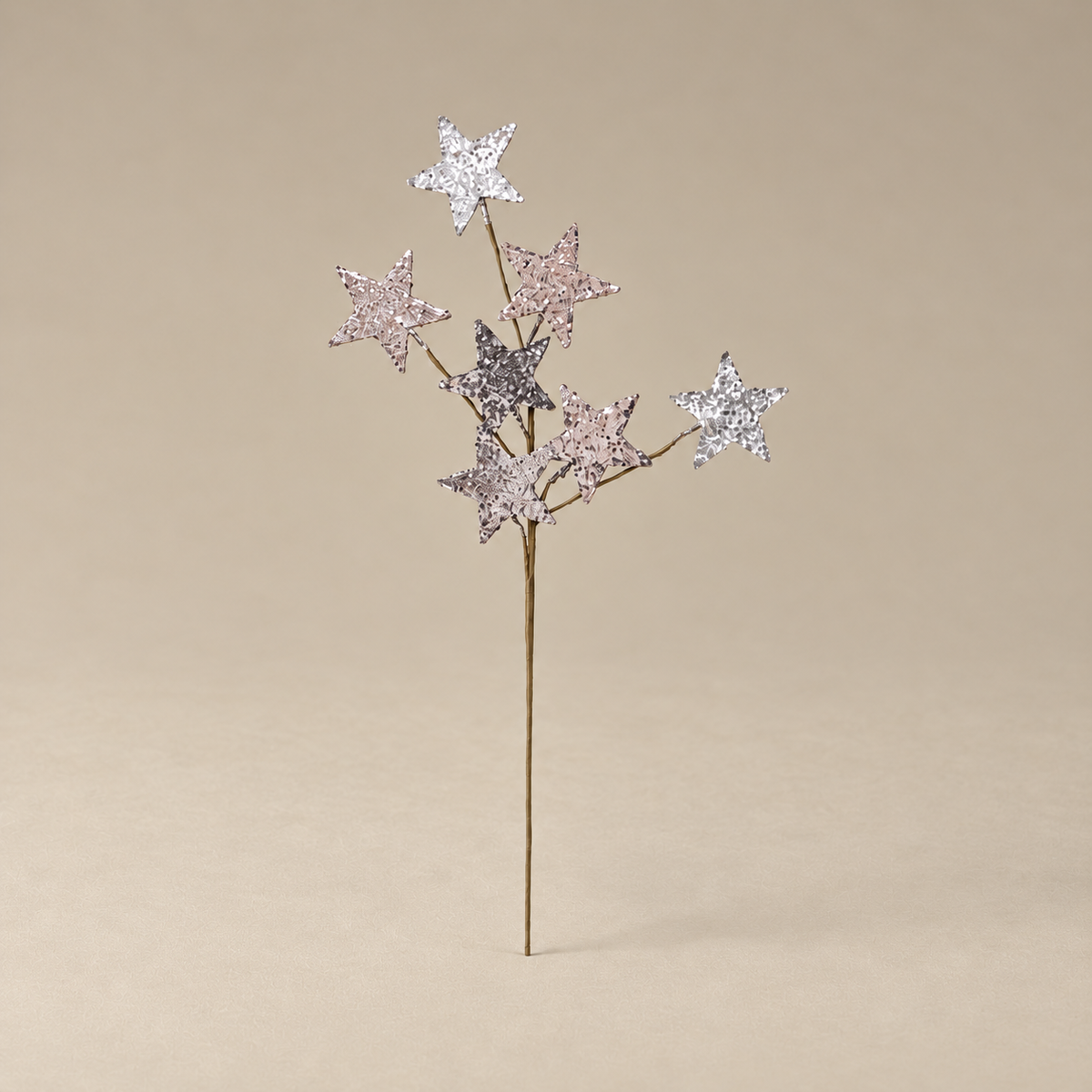 A decorative twig-style tree stake with five glittery star accents in silver, pink, and lavender tones, set against a solid beige background.