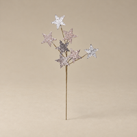 A decorative twig-style tree stake with five glittery star accents in silver, pink, and lavender tones, set against a solid beige background.