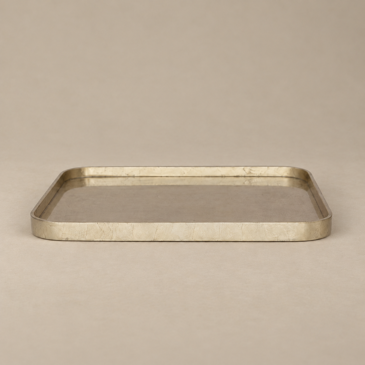 A rectangular metal tray with rounded corners and a brushed metallic finish, shown on a plain beige background.