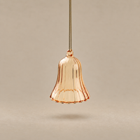 A single hanging pendant light shade made of translucent ribbed glass in a warm peachy rose-gold tone, suspended against a plain beige background.
