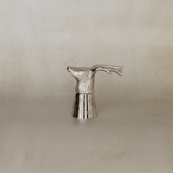 Silver deer head sculpture on a beige background