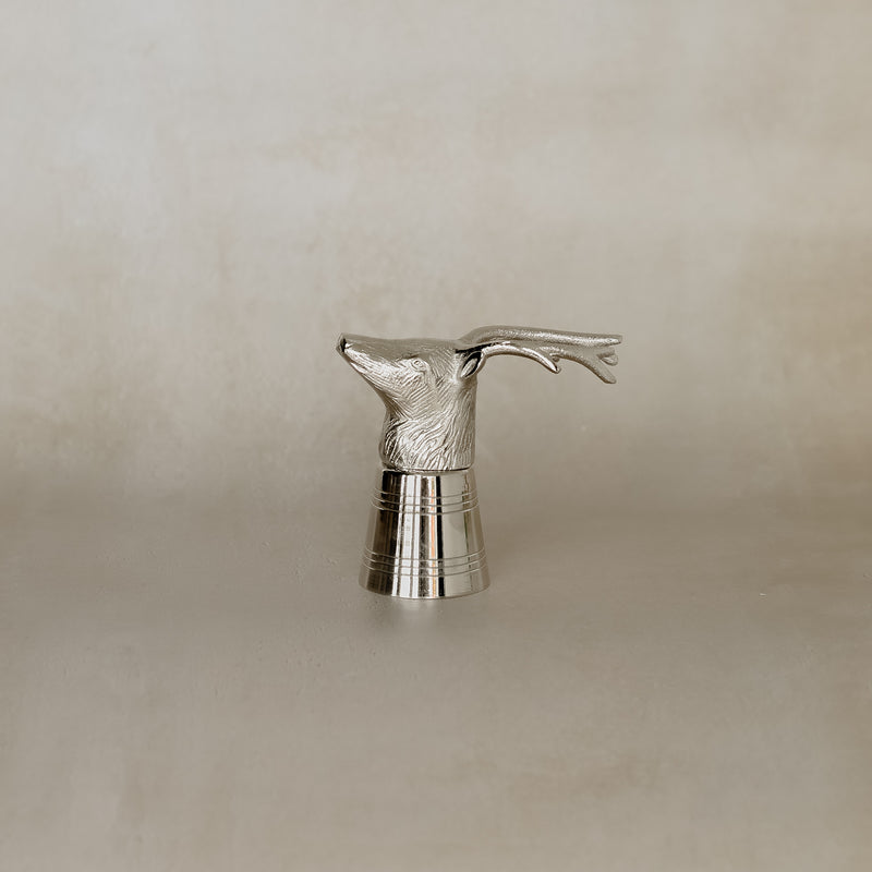 Silver deer head sculpture on a beige background
