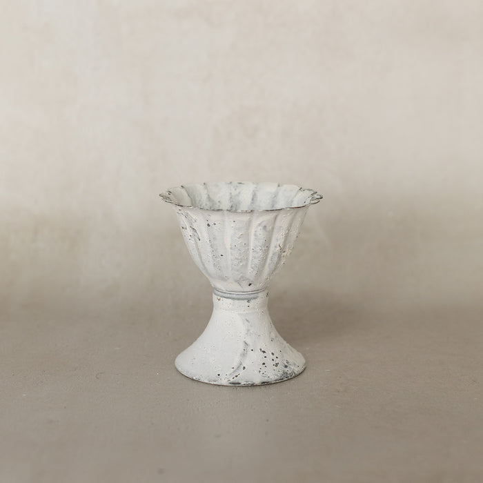 Decorative white vase with textured surface on a beige background