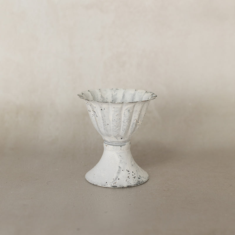 Decorative white vase with textured surface on a beige background