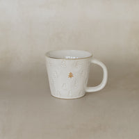 White ceramic mug with decorative elements on a beige background